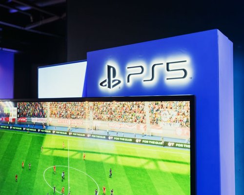 Smartphone displaying a fictional beginner-friendly game screen at a gaming exhibition